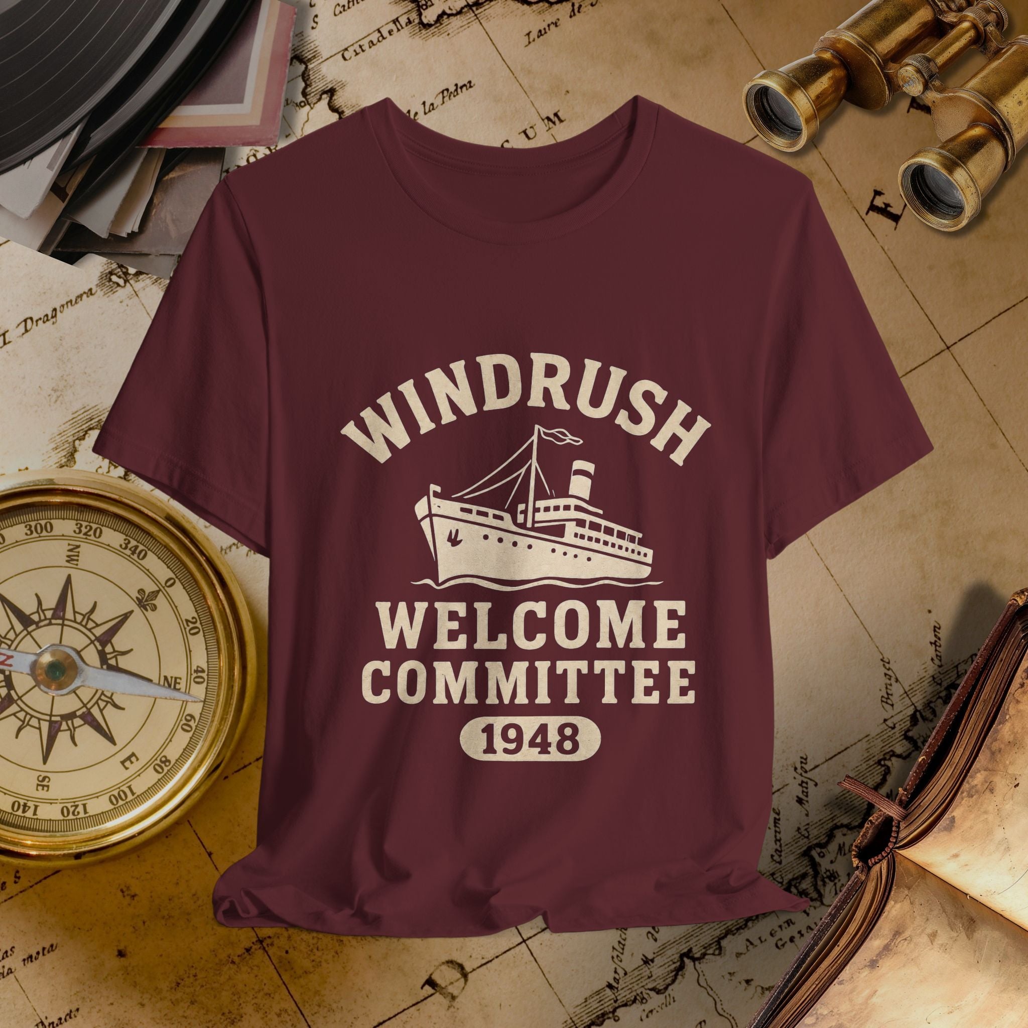 Maroon t-shirt with 'Windrush Welcome Committee 1948' design on a vintage map background.