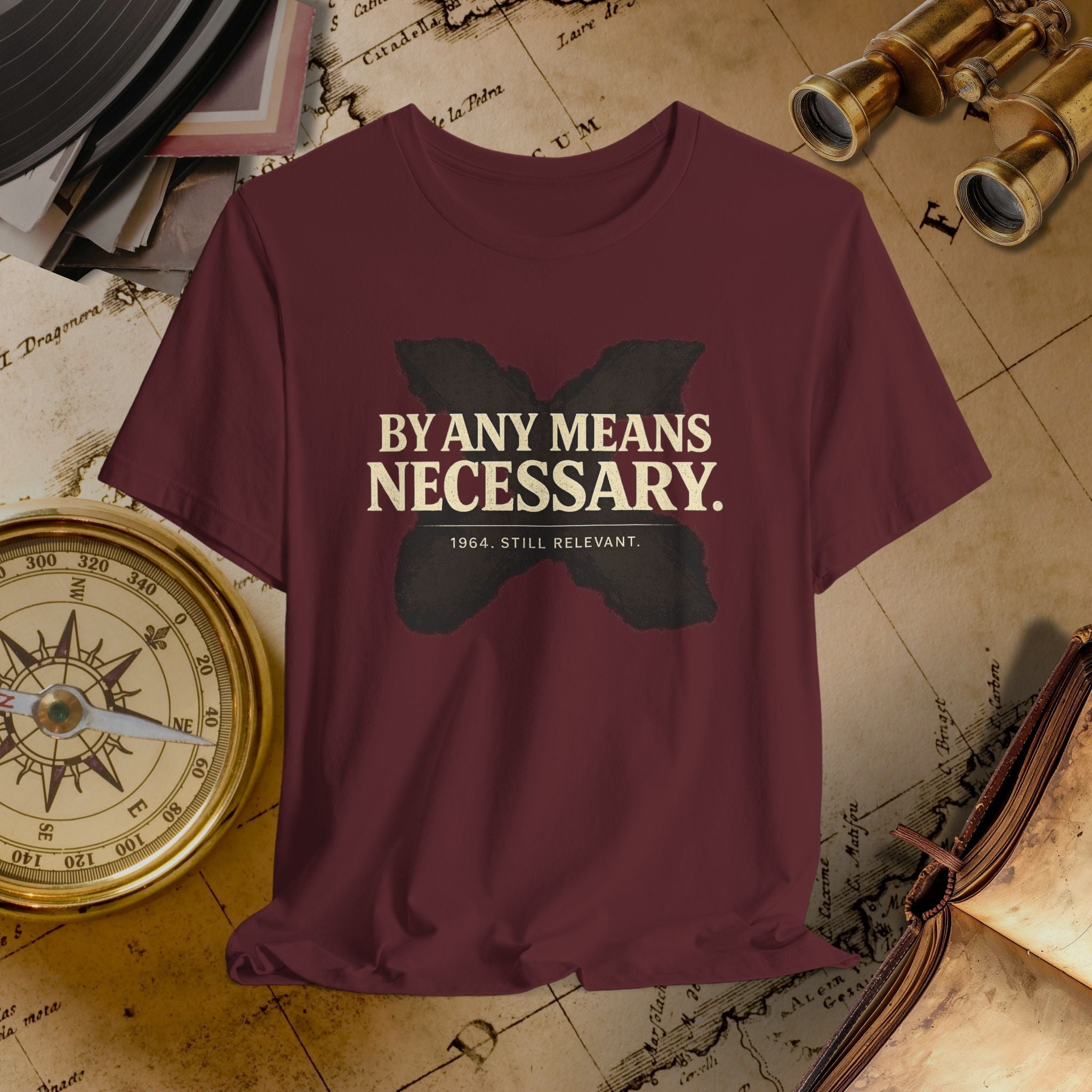 Maroon t-shirt with 'By Any Means Necessary' text and butterfly graphic on a vintage map background.