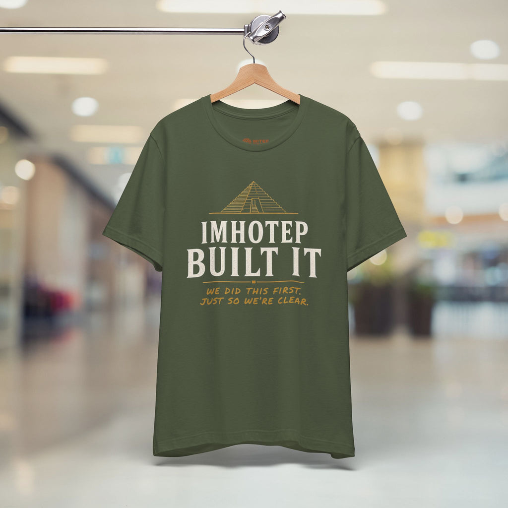 Green t-shirt on a hanger in a blurred indoor setting