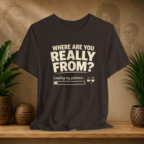 Brown t-shirt with humorous text design on a wooden surface with plants and decorative items in the background.