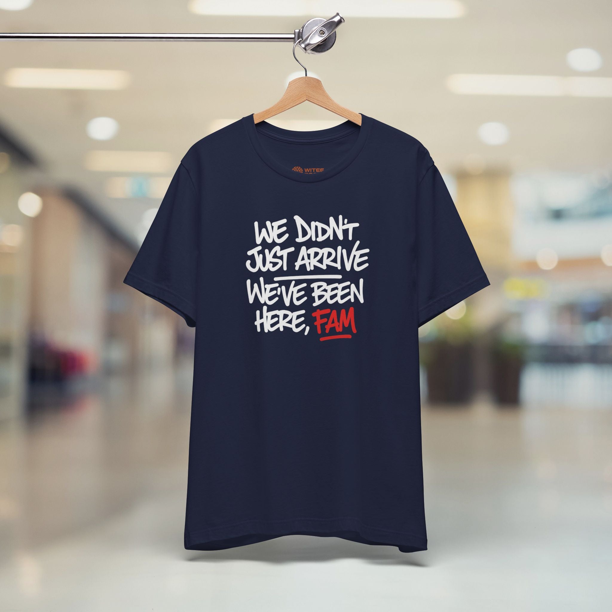 Navy blue t-shirt with humorous text design on a hanger in a mall setting