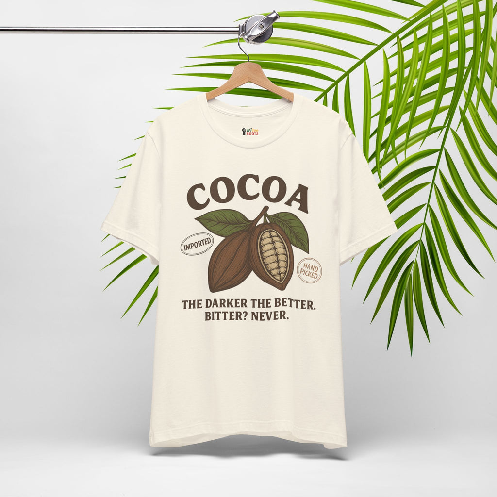 White t-shirt with cocoa graphic and text on a hanger with green leaves in the background