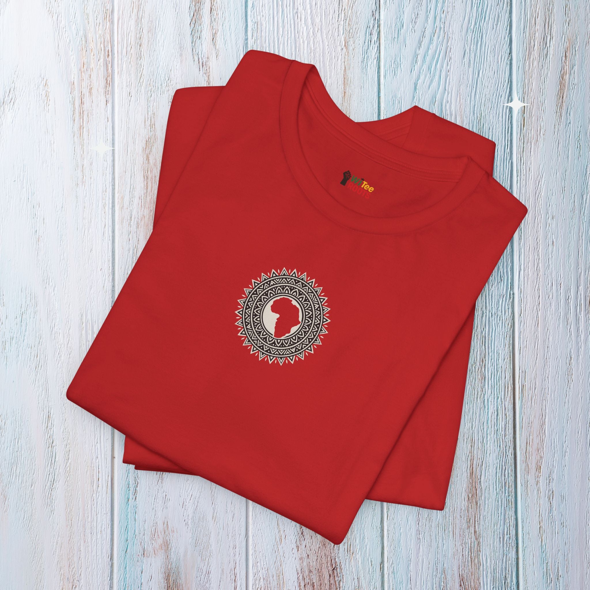 Folded red t-shirt with a circular design on a light wooden surface