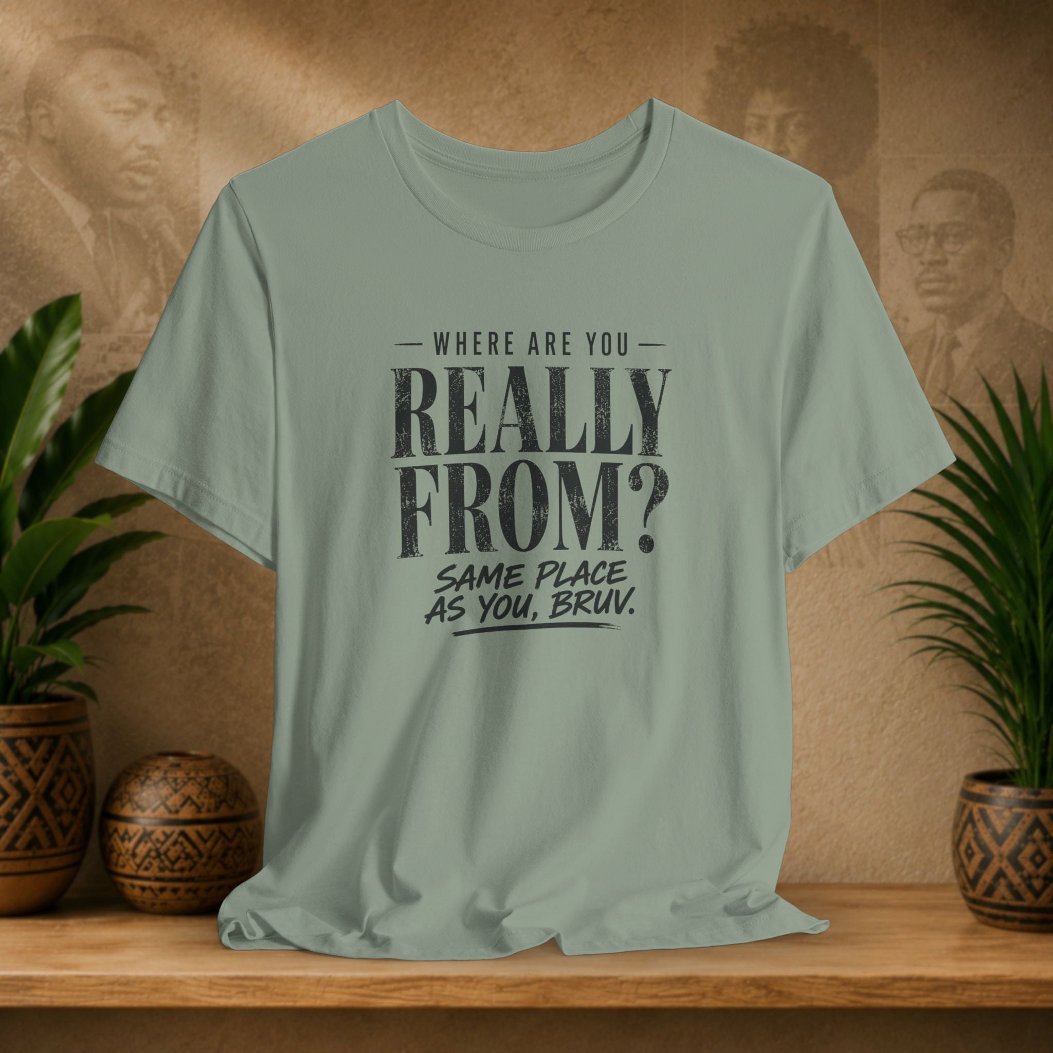 Light green t-shirt with humorous text design on a wooden surface with plants and a textured wall background.