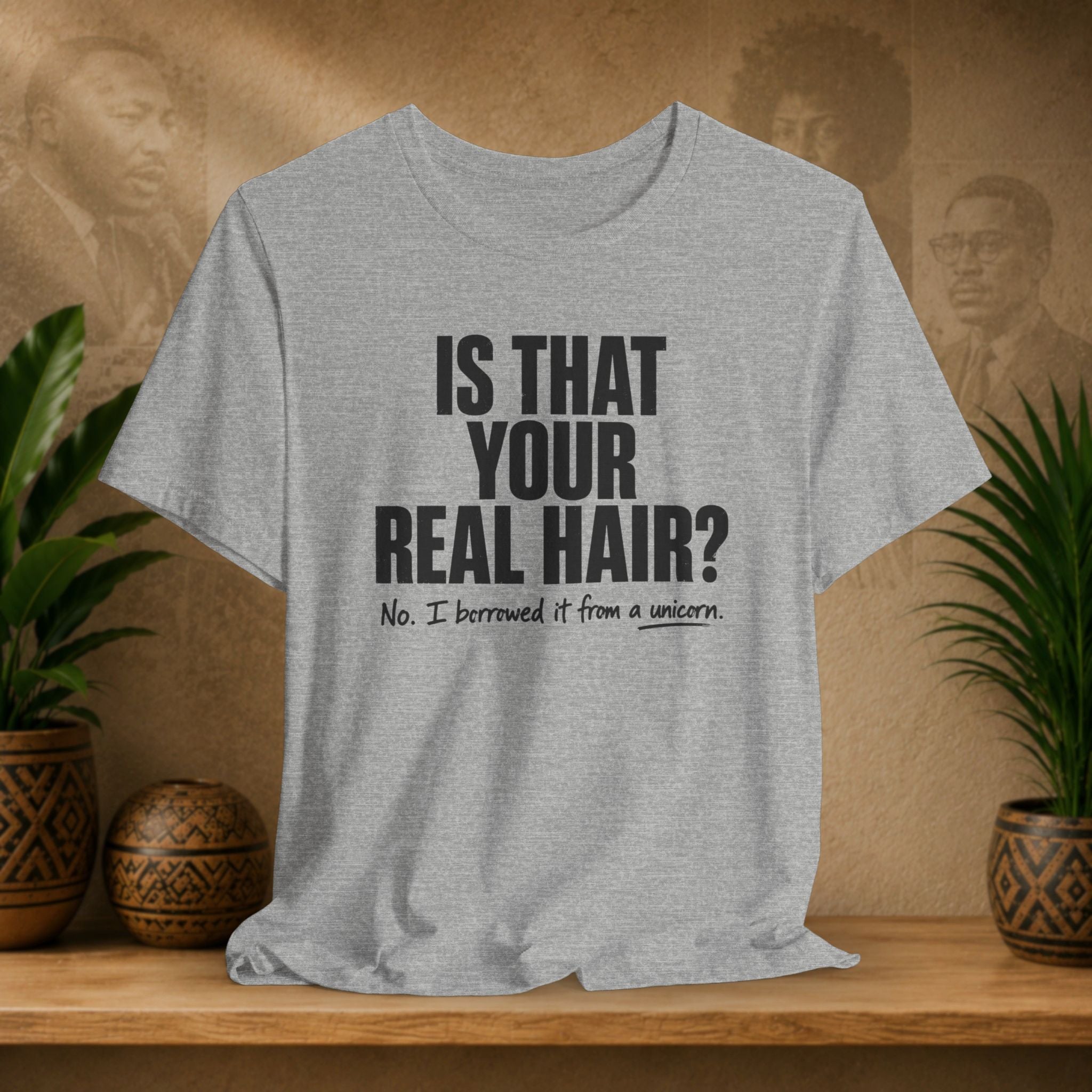 Gray t-shirt with humorous text design on a wooden surface with plants and a decorative item.