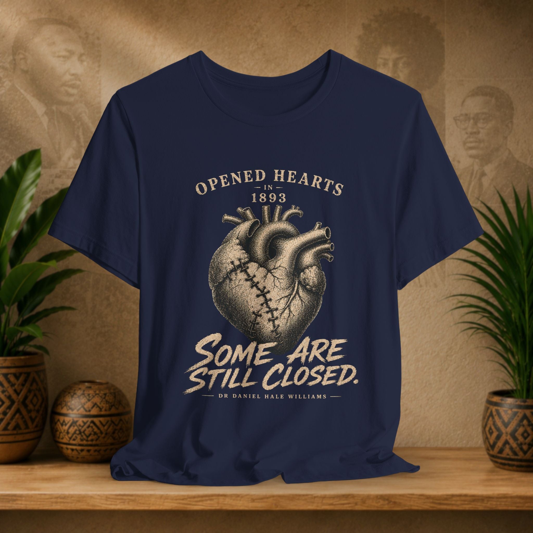 Navy blue t-shirt with heart graphic and text on a wooden surface with plants and decorative items.
