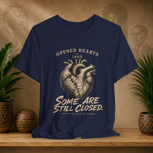 Navy blue t-shirt with heart graphic and text on a wooden surface with plants and decorative items.