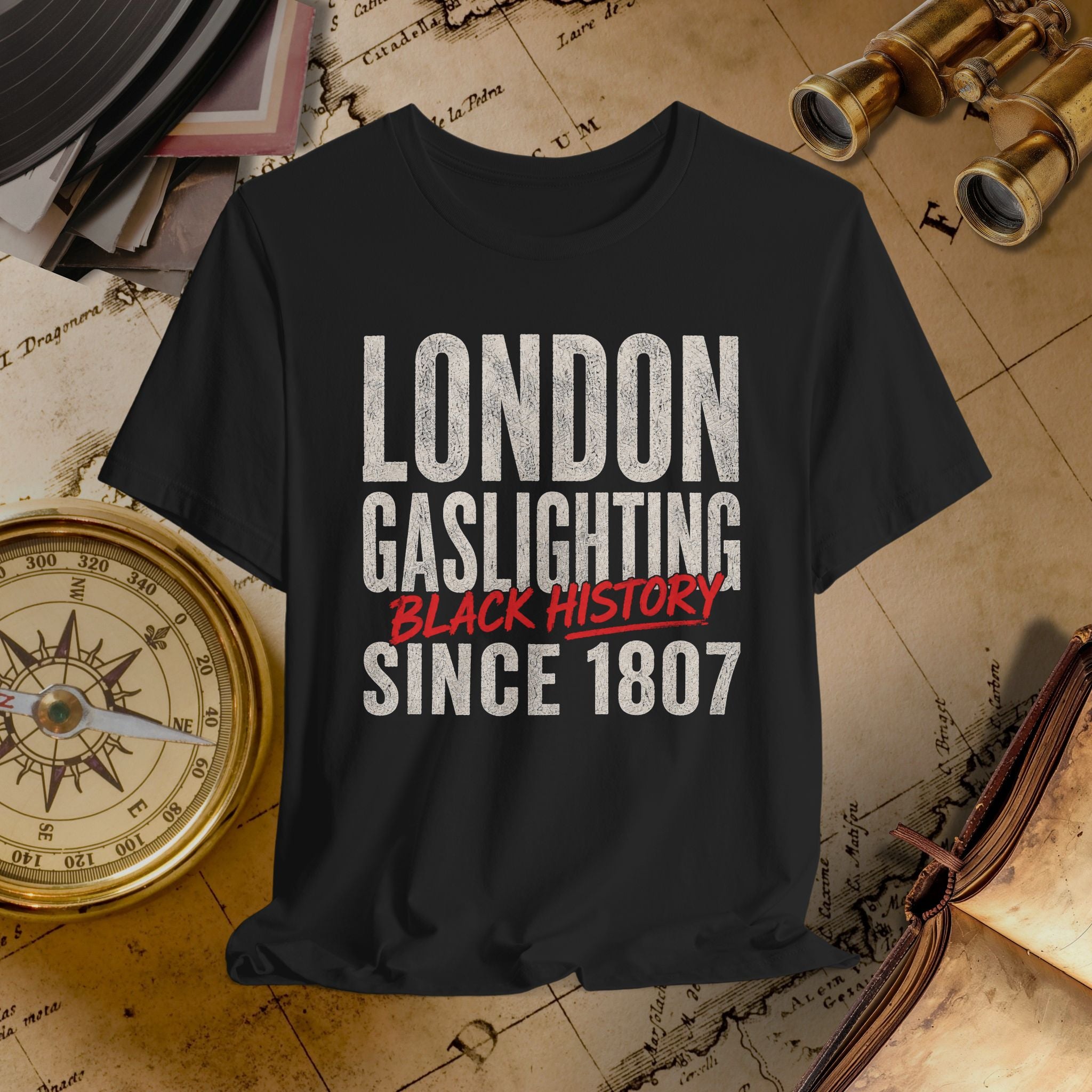 Black t-shirt with 'London Gaslighting Black History Since 1807' text on a vintage map background.