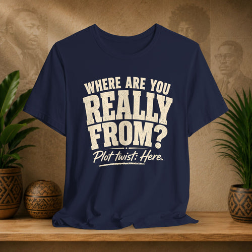Navy blue t-shirt with white text on a wooden surface with plants and a textured wall background