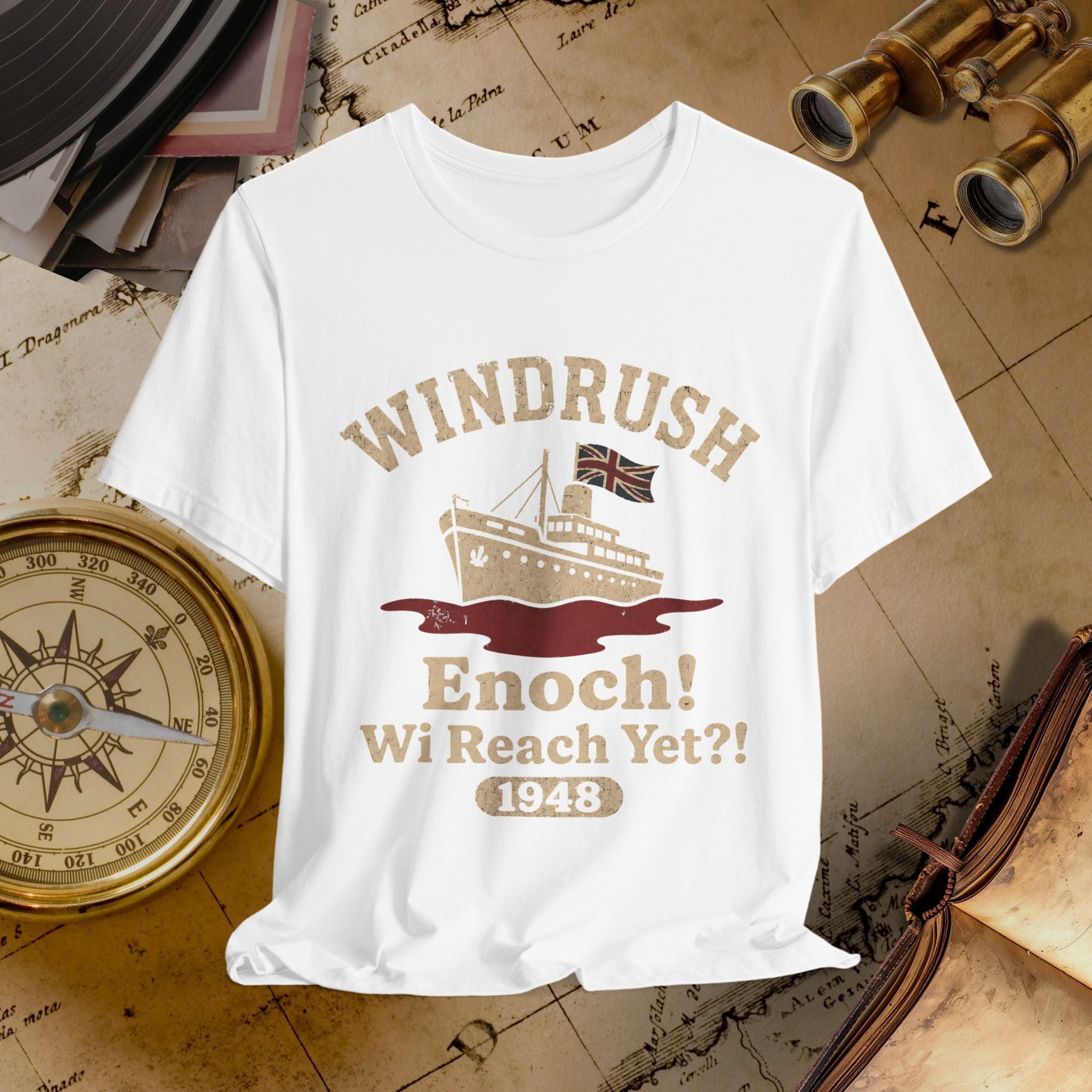 White t-shirt with 'Windrush' design featuring a ship and text on a vintage map background.