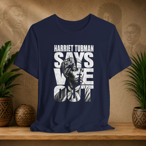 Navy blue t-shirt with Harriet Tubman graphic and text on a wooden surface with plants and decorative items.