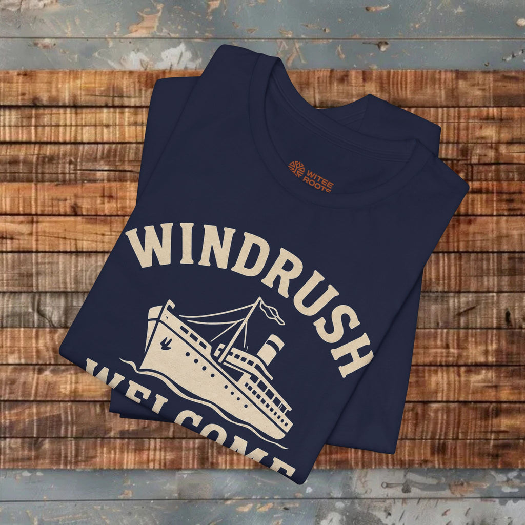 Folded navy blue t-shirt with 'Windrush Welcome' design on a wooden surface