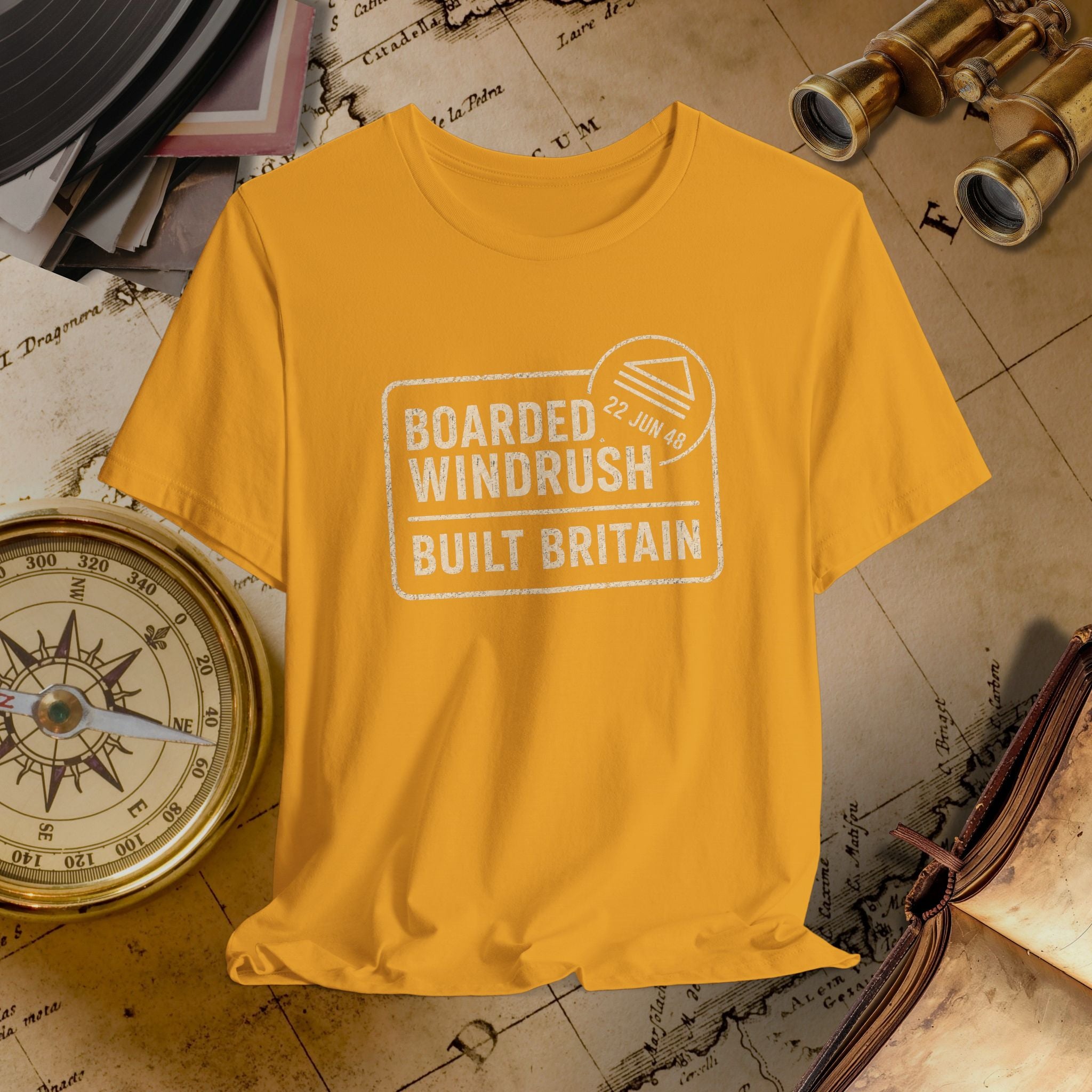 Mustard t-shirt with text 'Boarded Windrush Built Britain' on a vintage map background