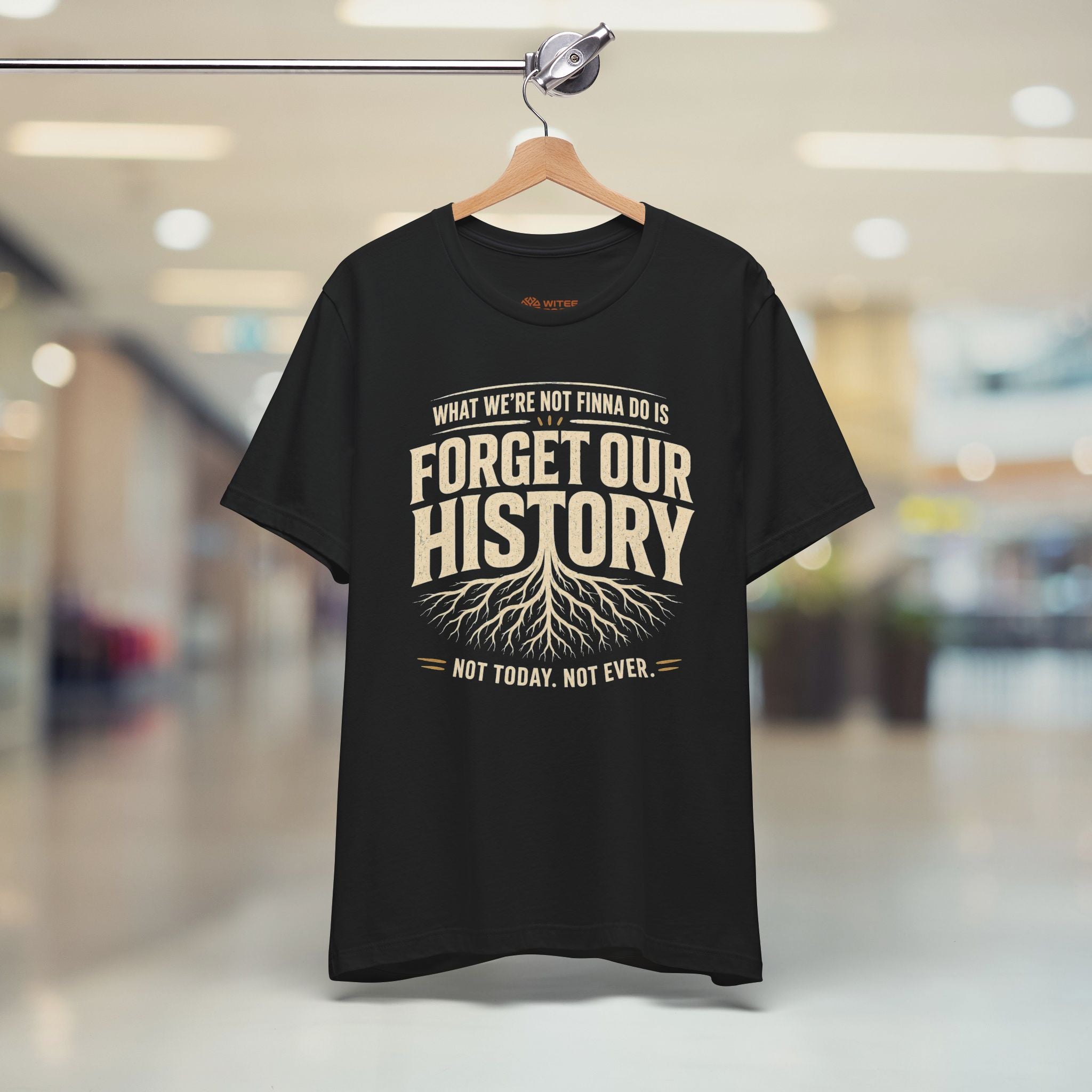 Black t-shirt with a printed message on a hanger in a store setting