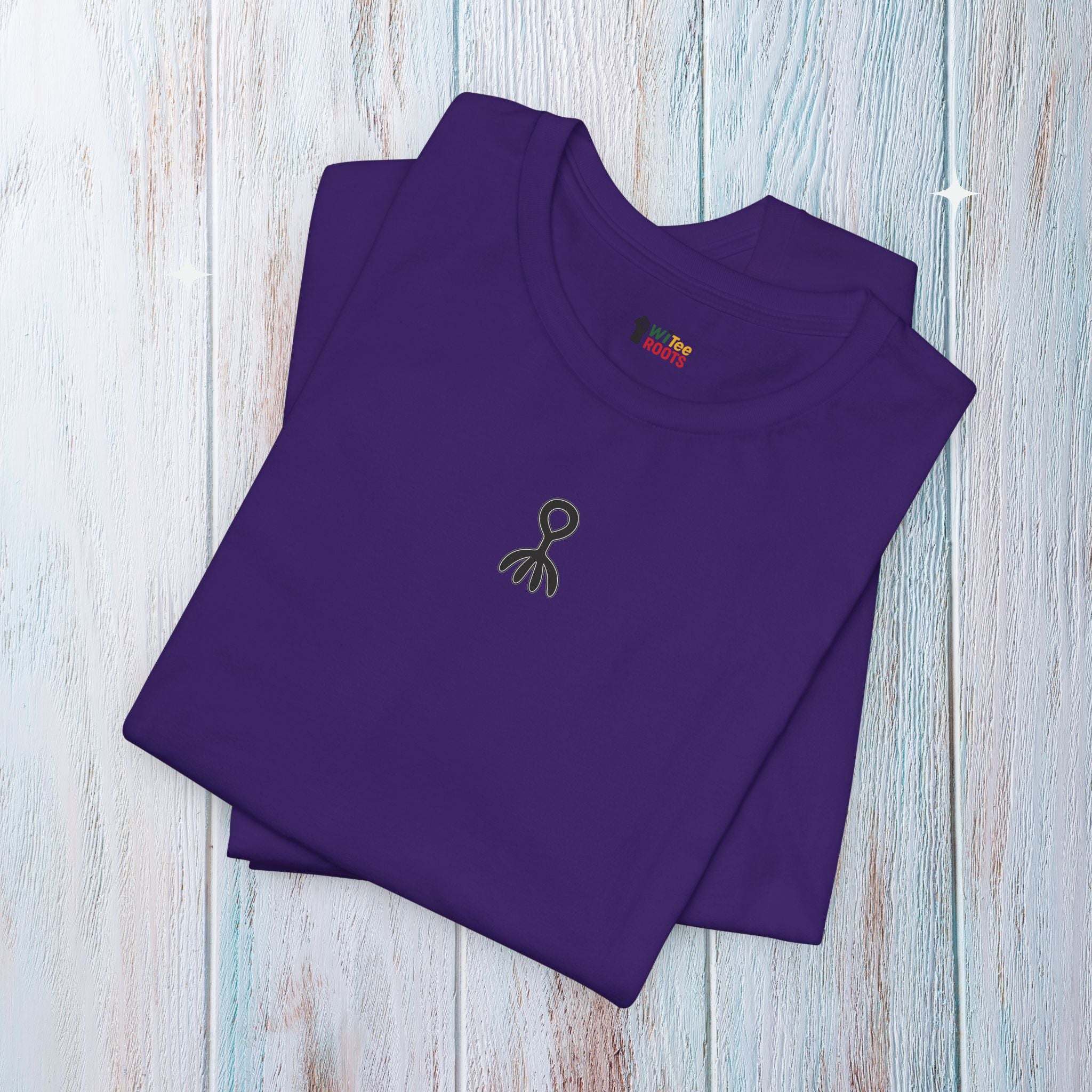 Folded purple t-shirt with a small logo on a light wooden surface