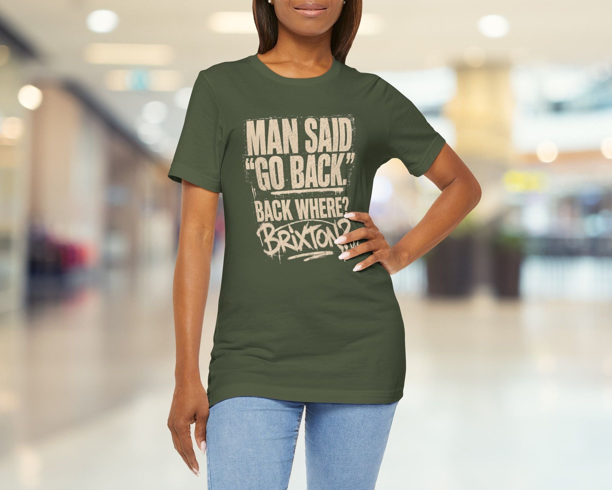 Woman wearing a green t-shirt with text in a blurred indoor setting