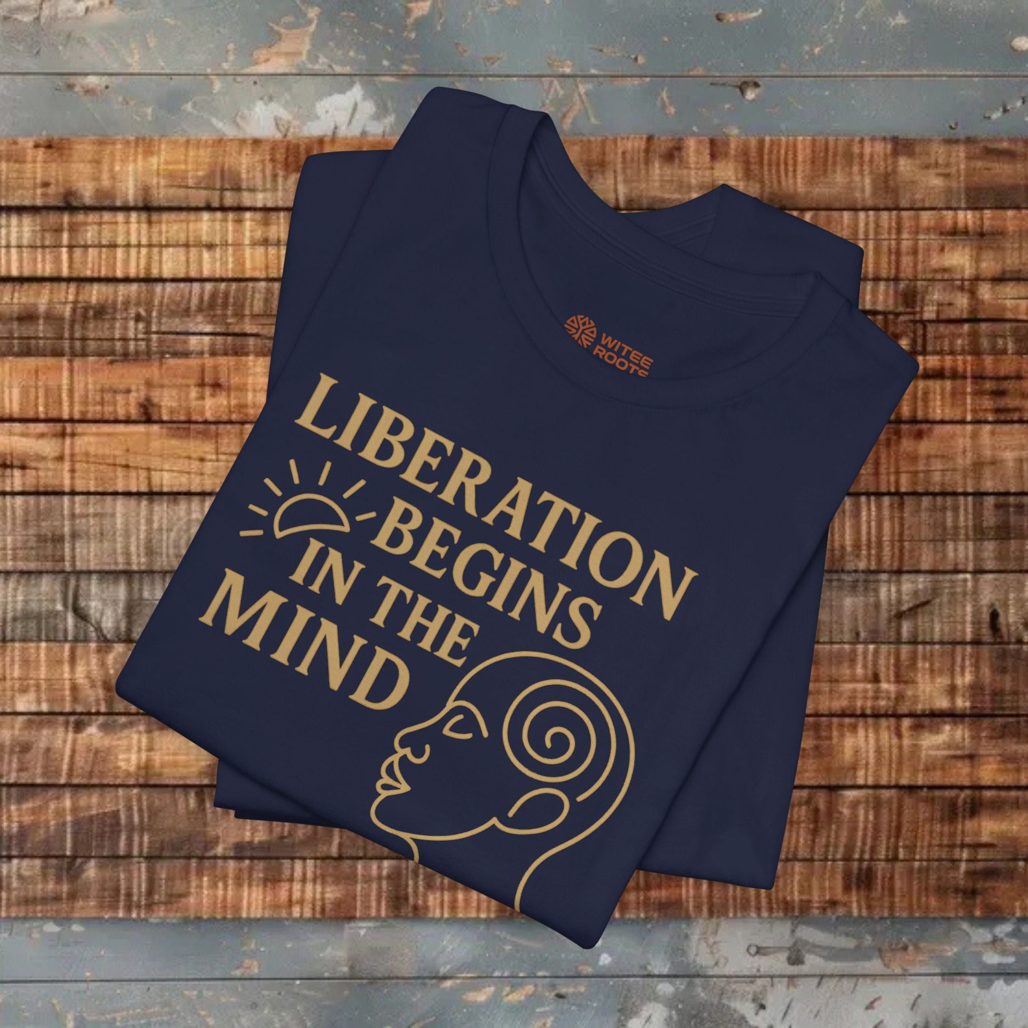 Folded navy blue t-shirt with gold text and design on a wooden surface