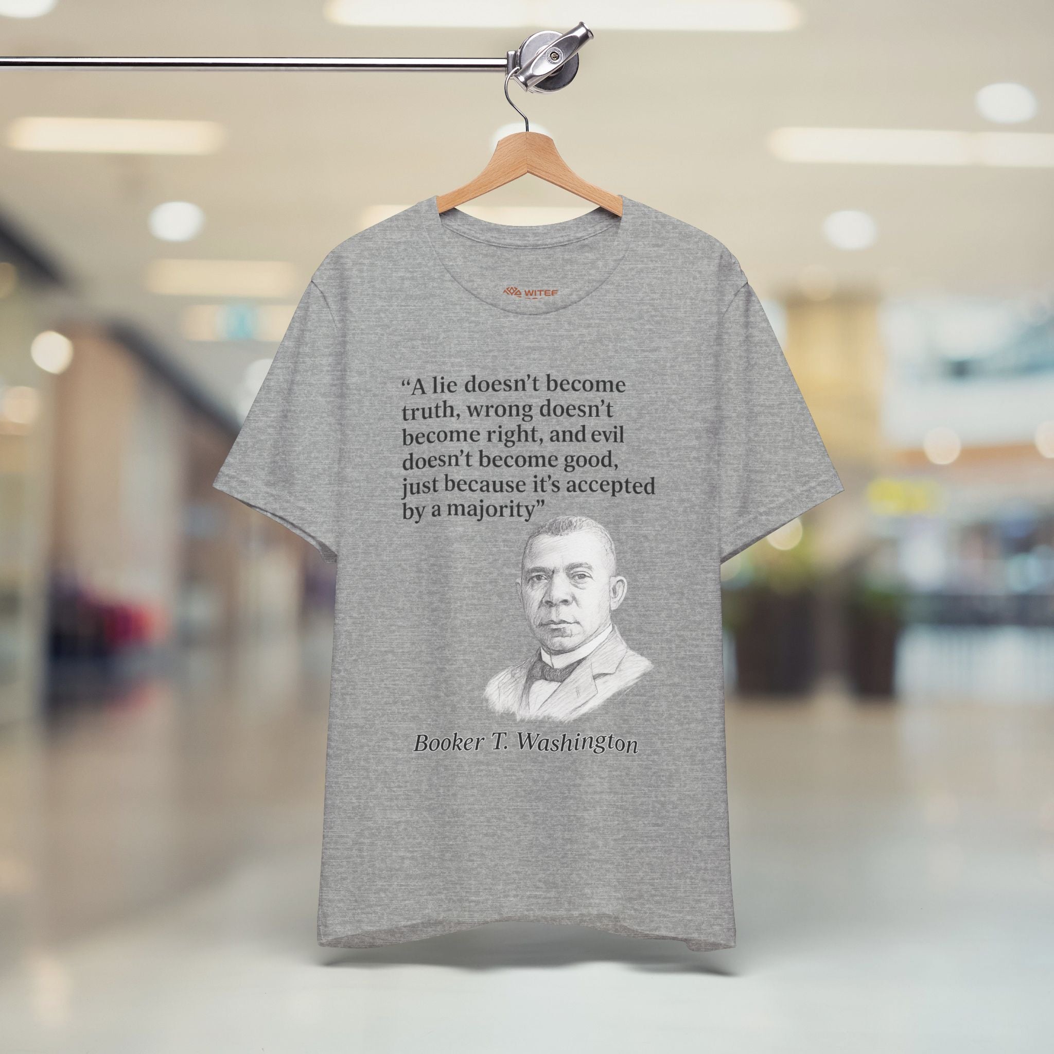 Gray t-shirt with Booker T. Washington quote on a hanger in a store setting