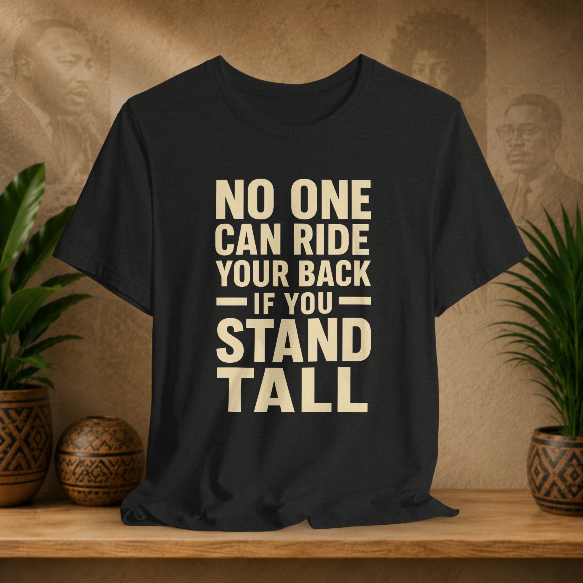 Black t-shirt with motivational quote on a wooden surface with decorative plants and background.