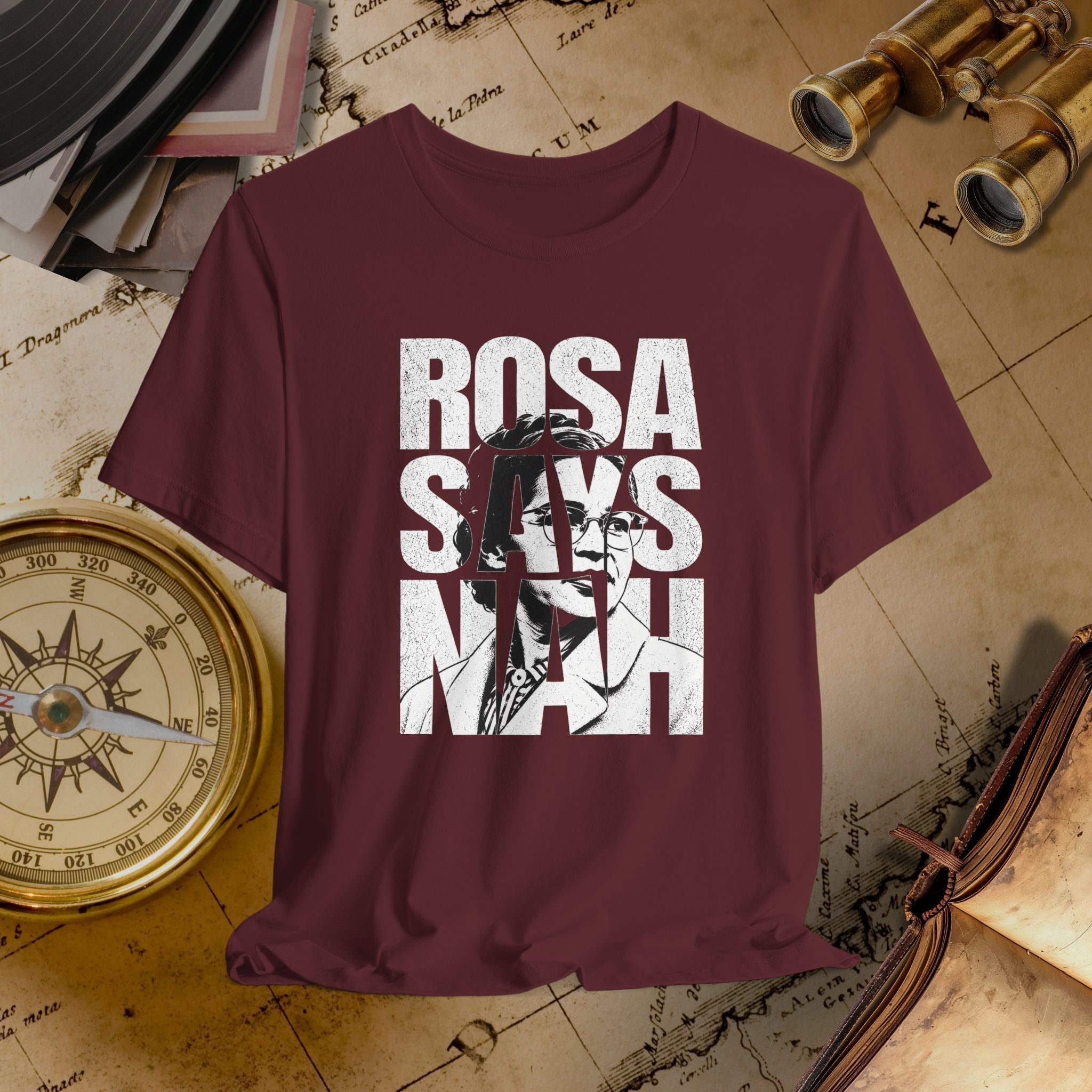 Maroon t-shirt with 'ROSA SAYS NAAH' text and graphic on a vintage map background