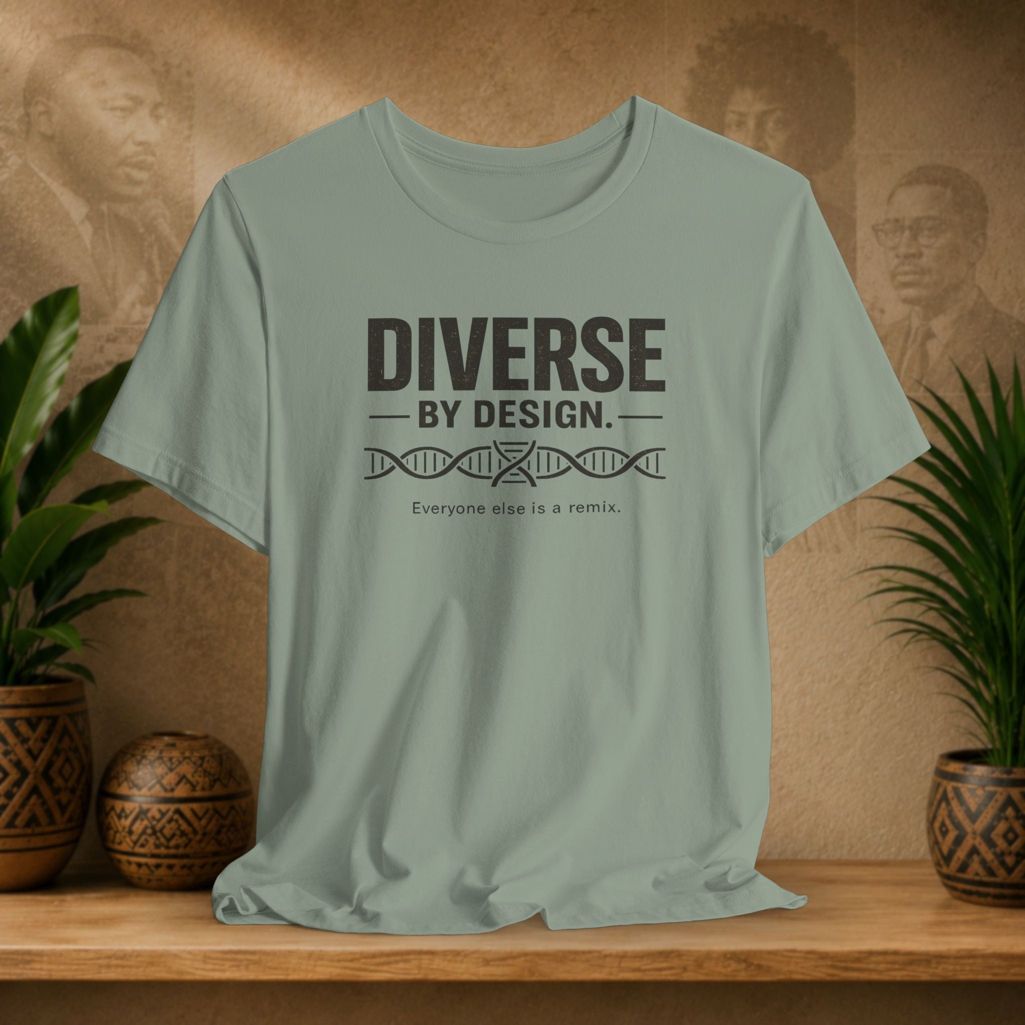 Green t-shirt with 'Diverse by Design' text on a wooden surface with plants and a textured wall background