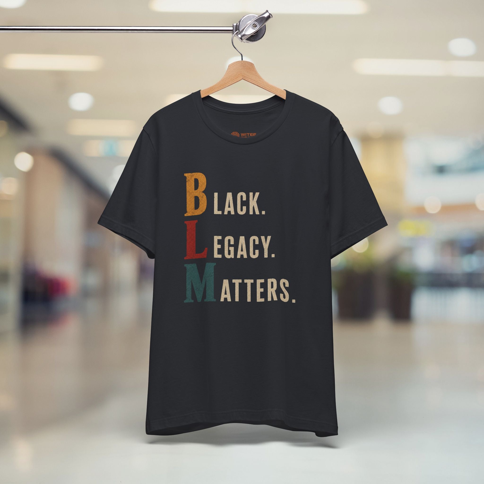 Navy blue t-shirt with graphic design and text on a hanger in a store.
