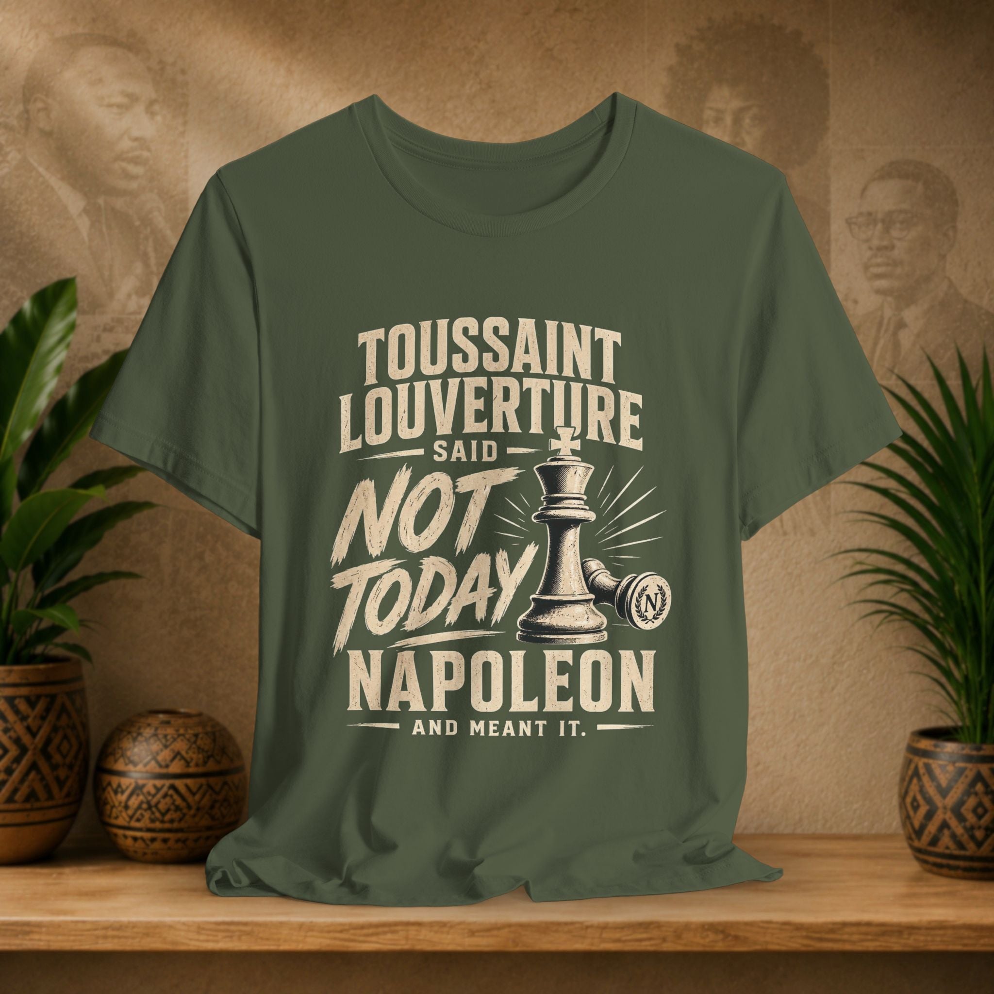 Green t-shirt with historical quote design on a wooden surface with decorative plants.