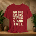 Red t-shirt with motivational quote on a wooden surface with decorative plants and background.