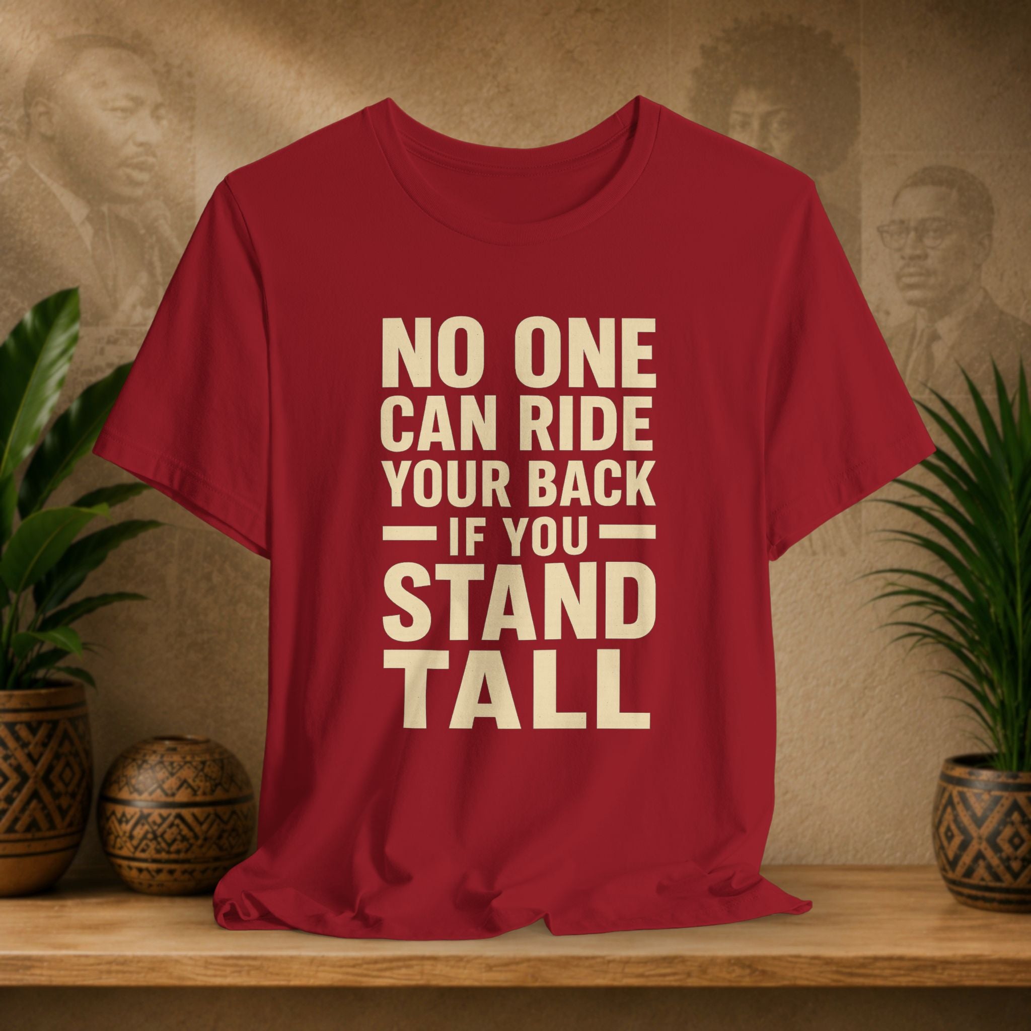 Red t-shirt with motivational quote on a wooden surface with decorative plants and background.
