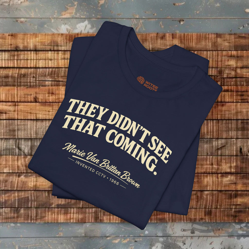 Folded navy blue t-shirt with white text on a wooden surface