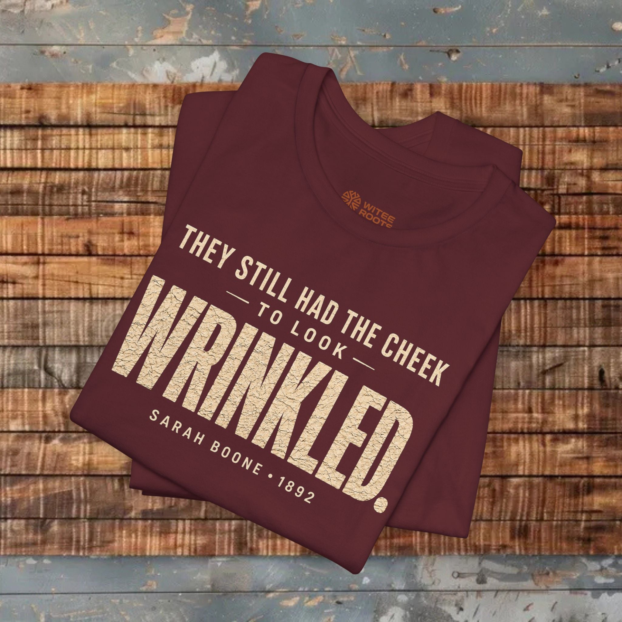 Maroon sweatshirt with text on a wooden surface