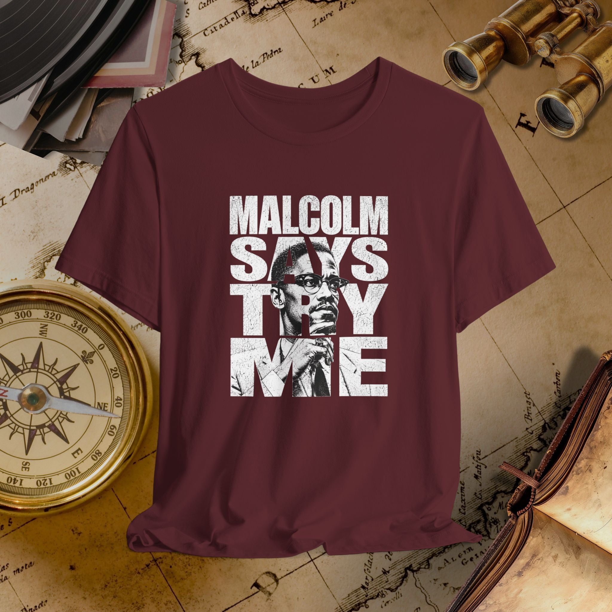 Maroon t-shirt with 'Malcolm Says Try Me' graphic on a vintage map background