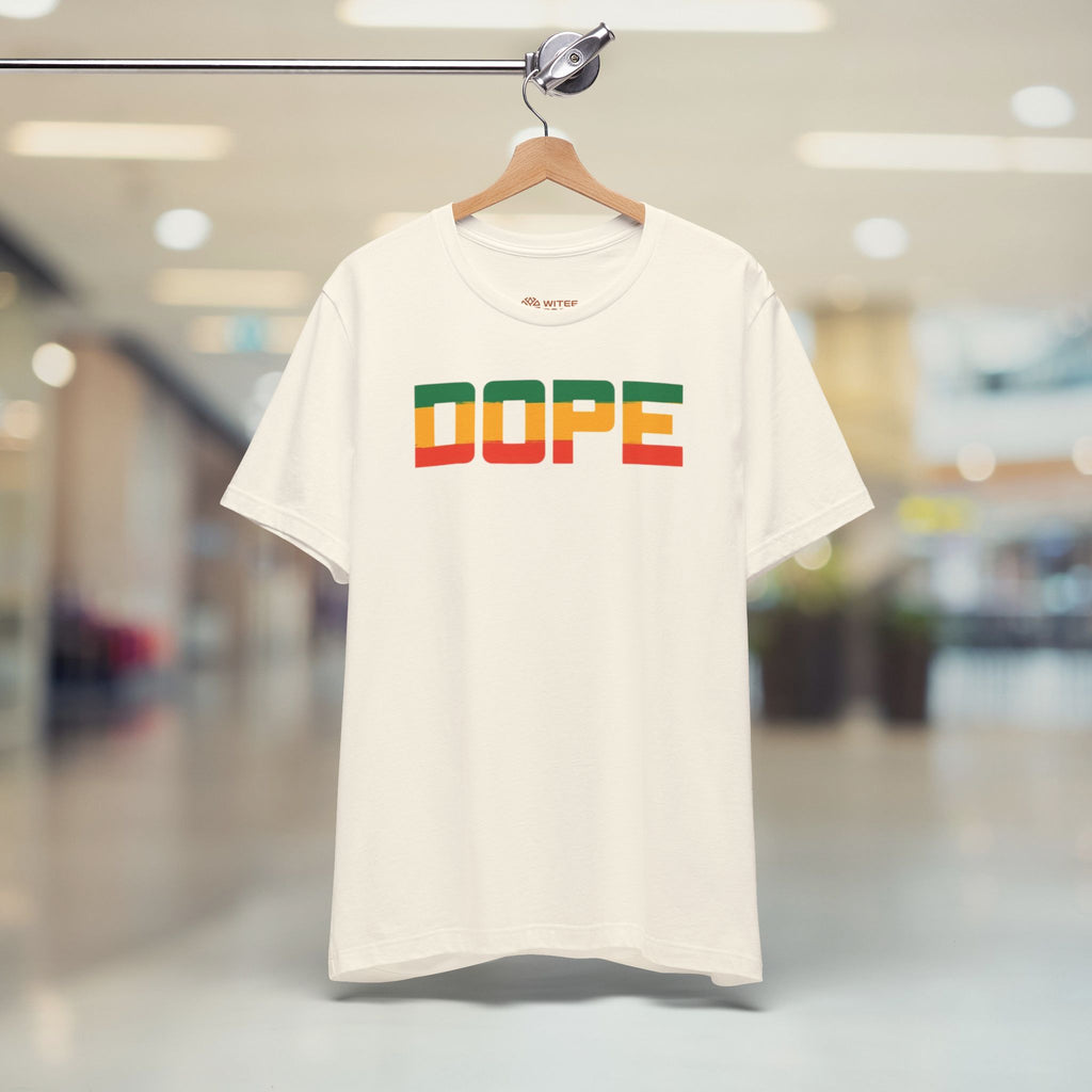 White t-shirt with 'DOPE' in colorful letters on a hanger in a store.