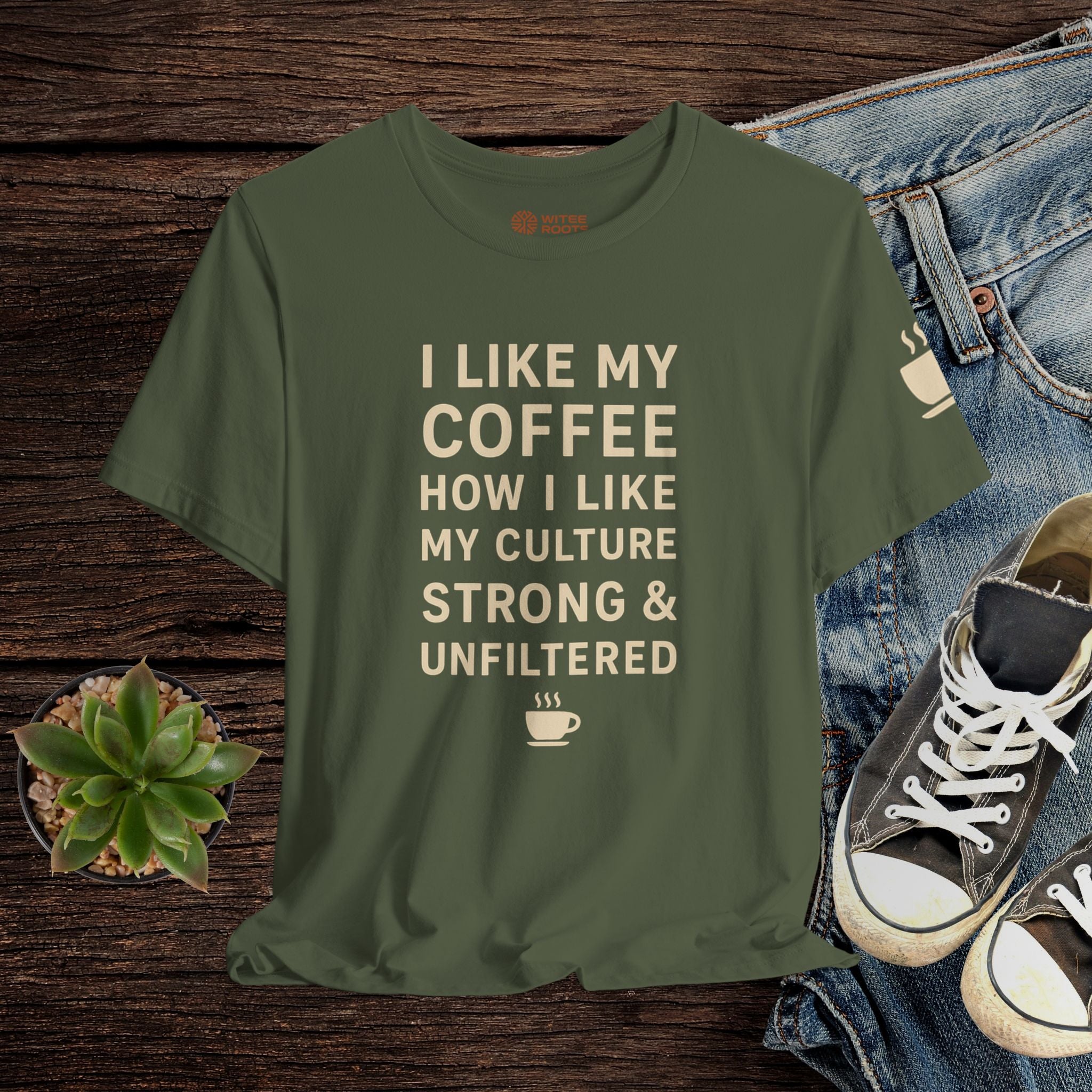 Green t-shirt with text on a wooden surface with jeans and sneakers.