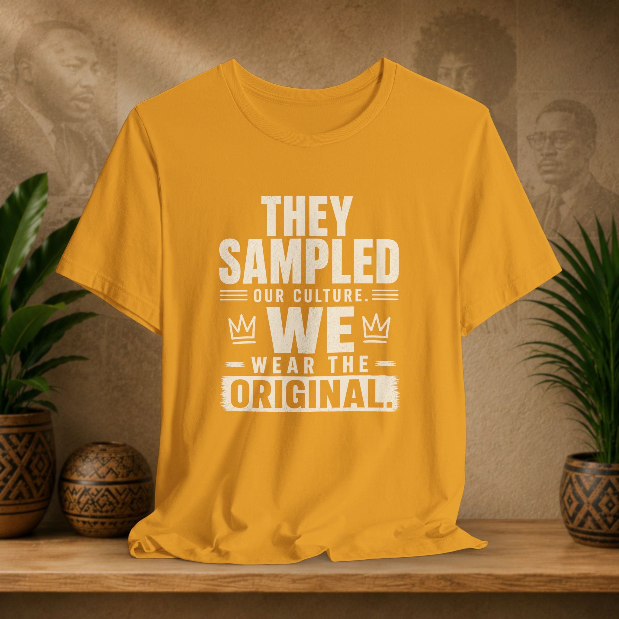 Yellow t-shirt with text on a wooden surface with plants and a textured wall background
