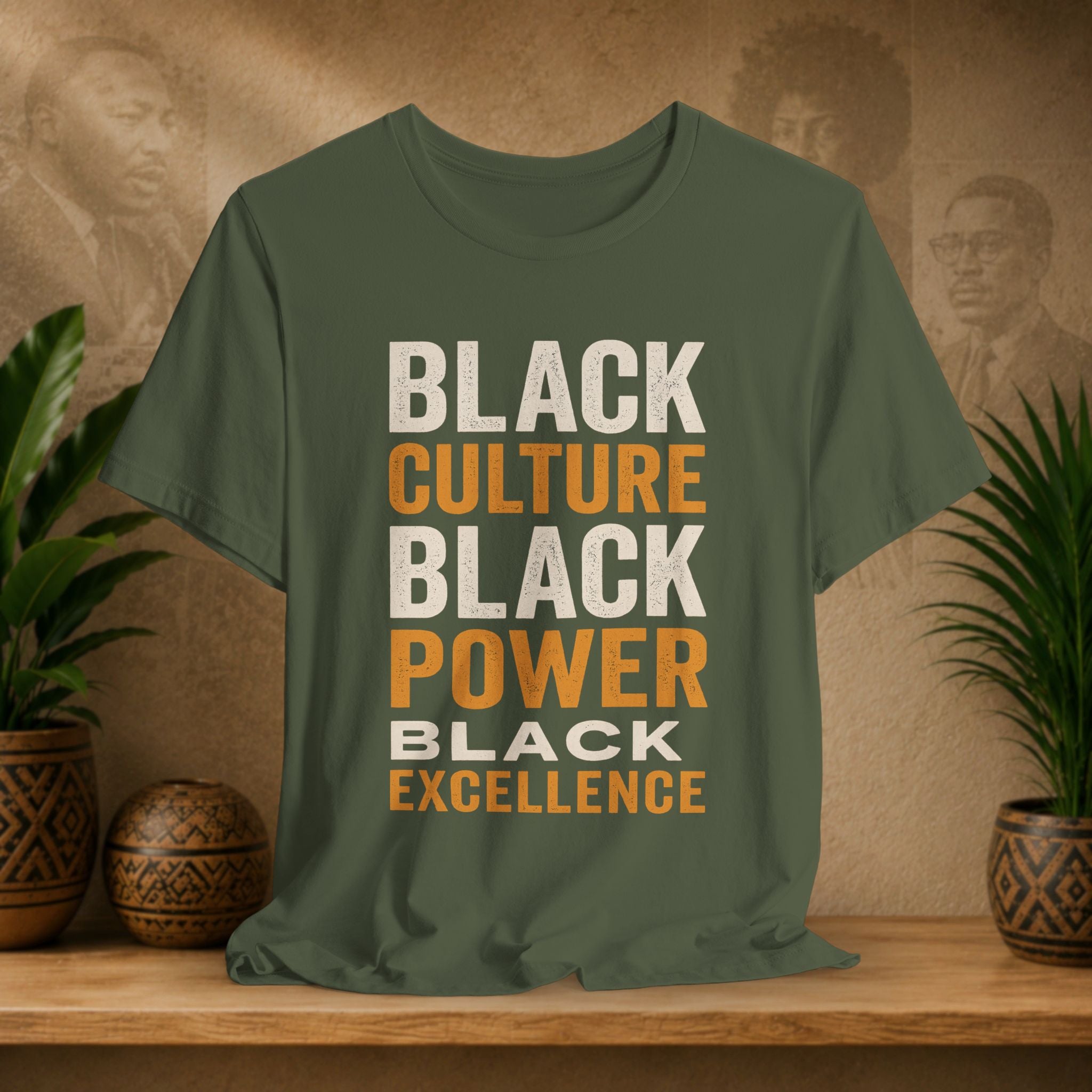 Green t-shirt with 'Black Culture, Black Power, Black Excellence' text on a wooden surface with plants and decorative items.
