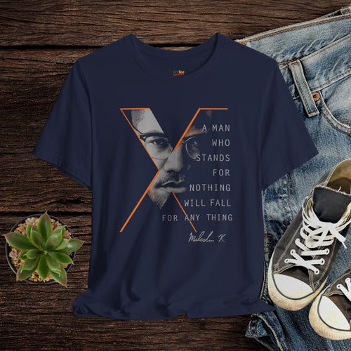Navy blue t-shirt with graphic design and text on a wooden surface with jeans and sneakers.