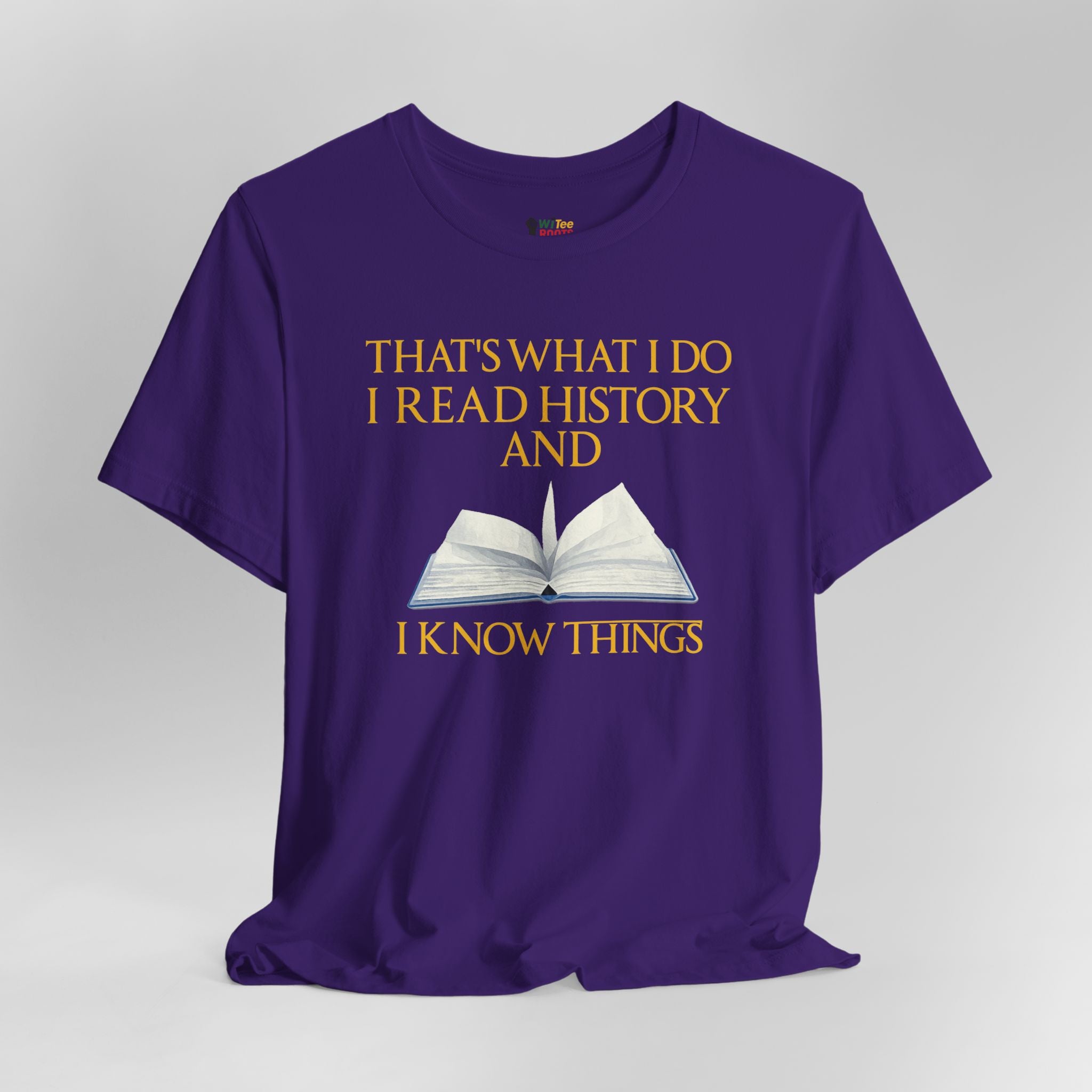 Purple t-shirt with yellow text and an open book graphic on a gray background