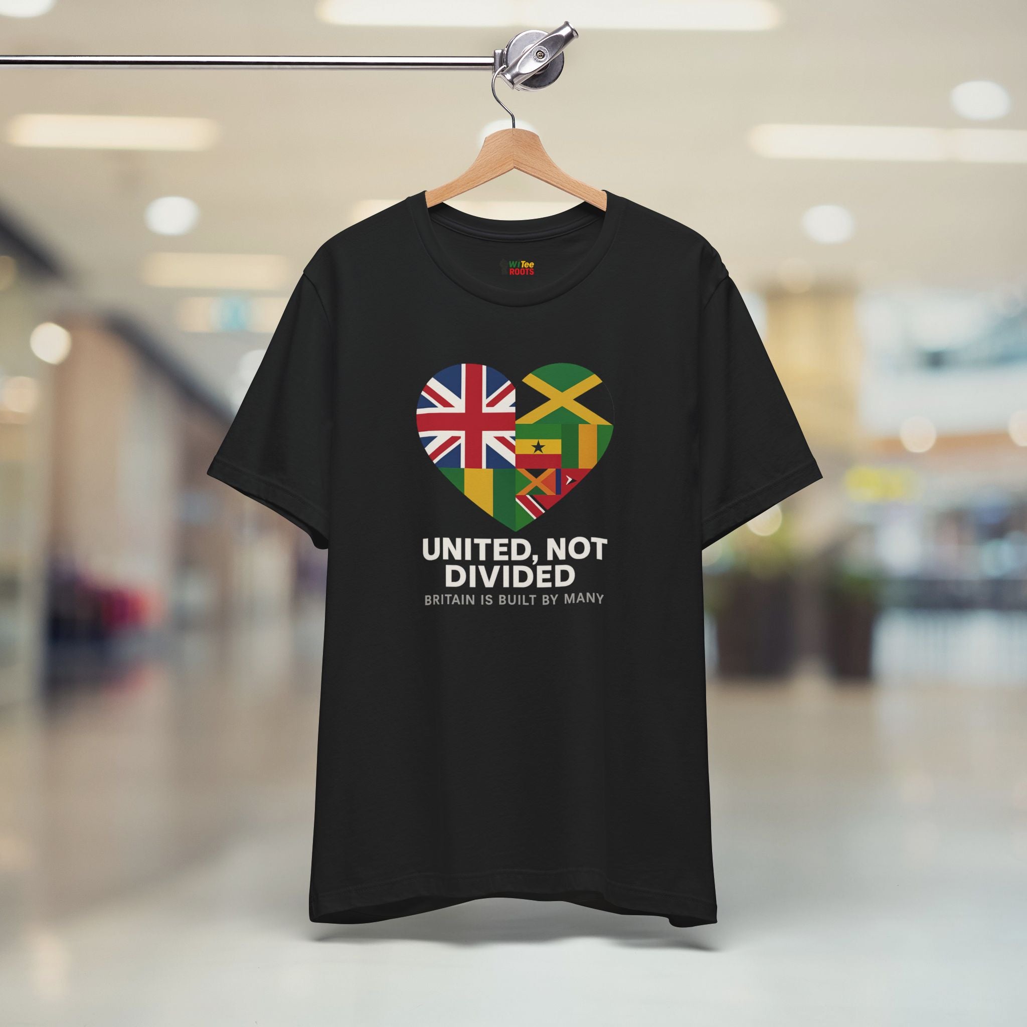 Black t-shirt with a heart-shaped design of British and Jamaican flags and text 'UNITED, NOT DIVIDED' on a hanger.