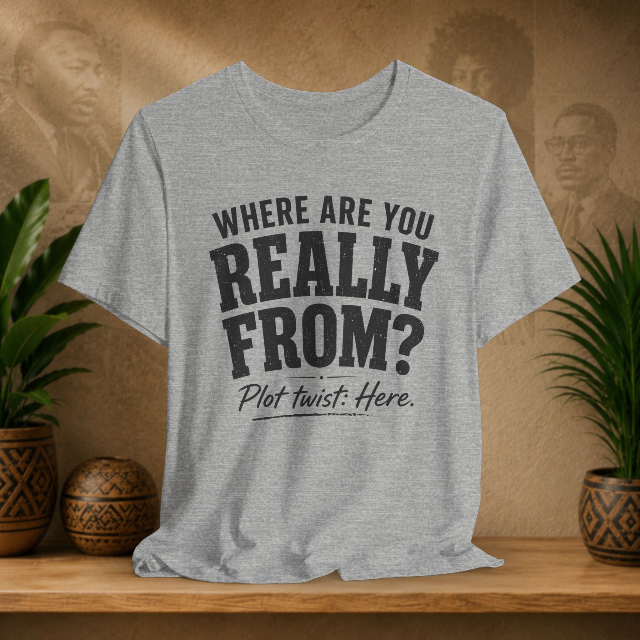 Gray t-shirt with humorous text design on a wooden surface with plants and a decorative wall.