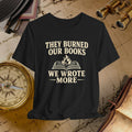 Black t-shirt with 'They burned our books, we wrote more' text on a vintage background with books and binoculars.