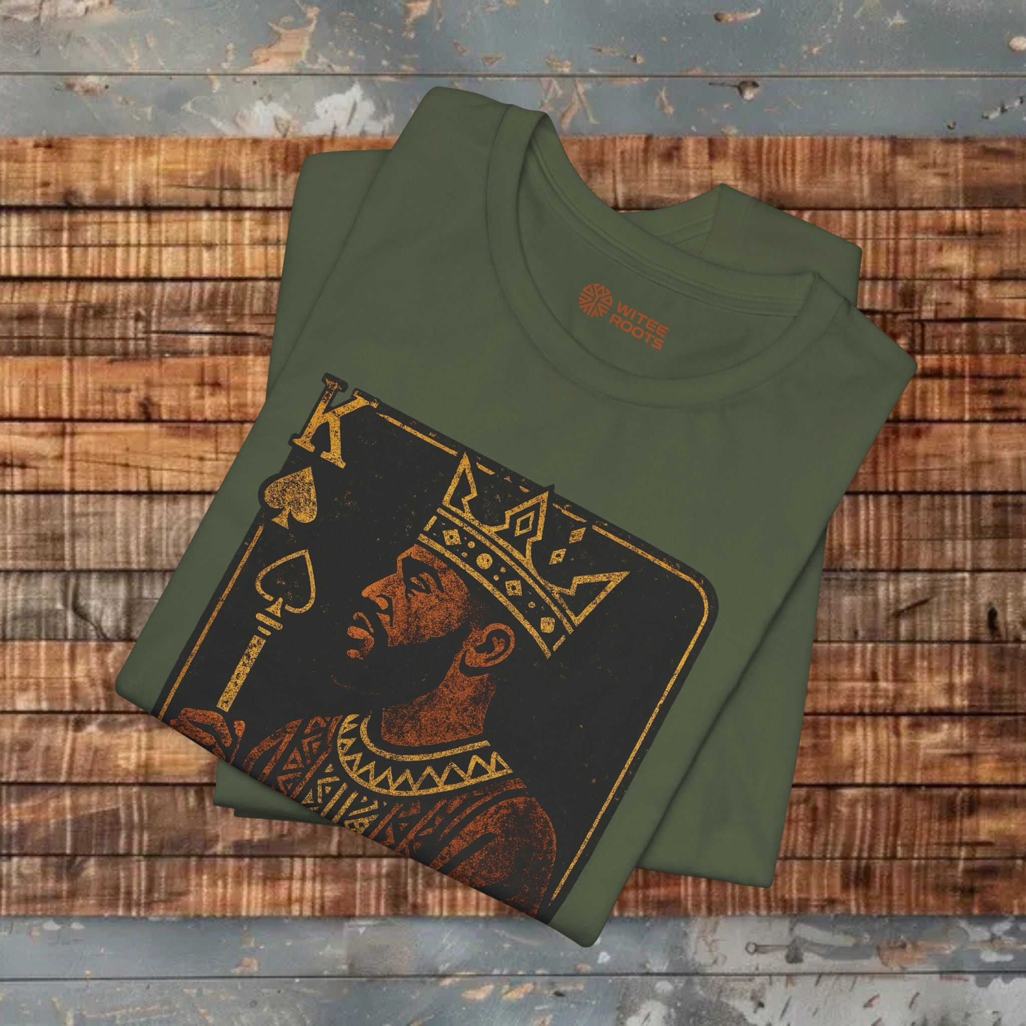 Folded green t-shirt with a graphic design on a wooden surface