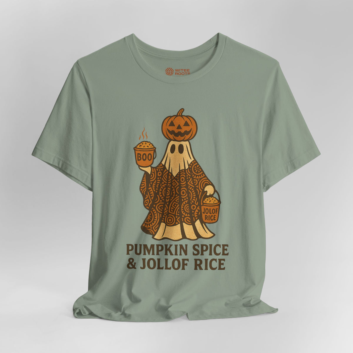 A sage green t-shirt with a Halloween graphic of a ghost in a paisley pattern holding a pumpkin and a bucket, with the text 'PUMPKIN SPICE & JOLLOF RICE' underneath. The shirt is displayed on a neutral gray background.