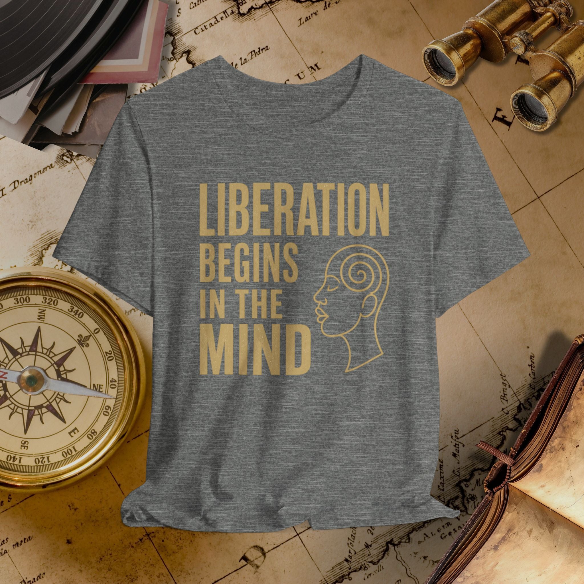 Gray t-shirt with 'Liberation Begins in the Mind' text and graphic on a vintage map background