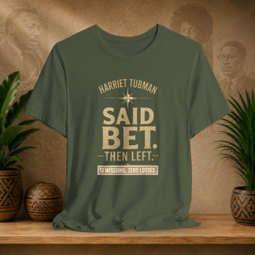 Green t-shirt with text on a wooden surface with plants and a decorative wall in the background