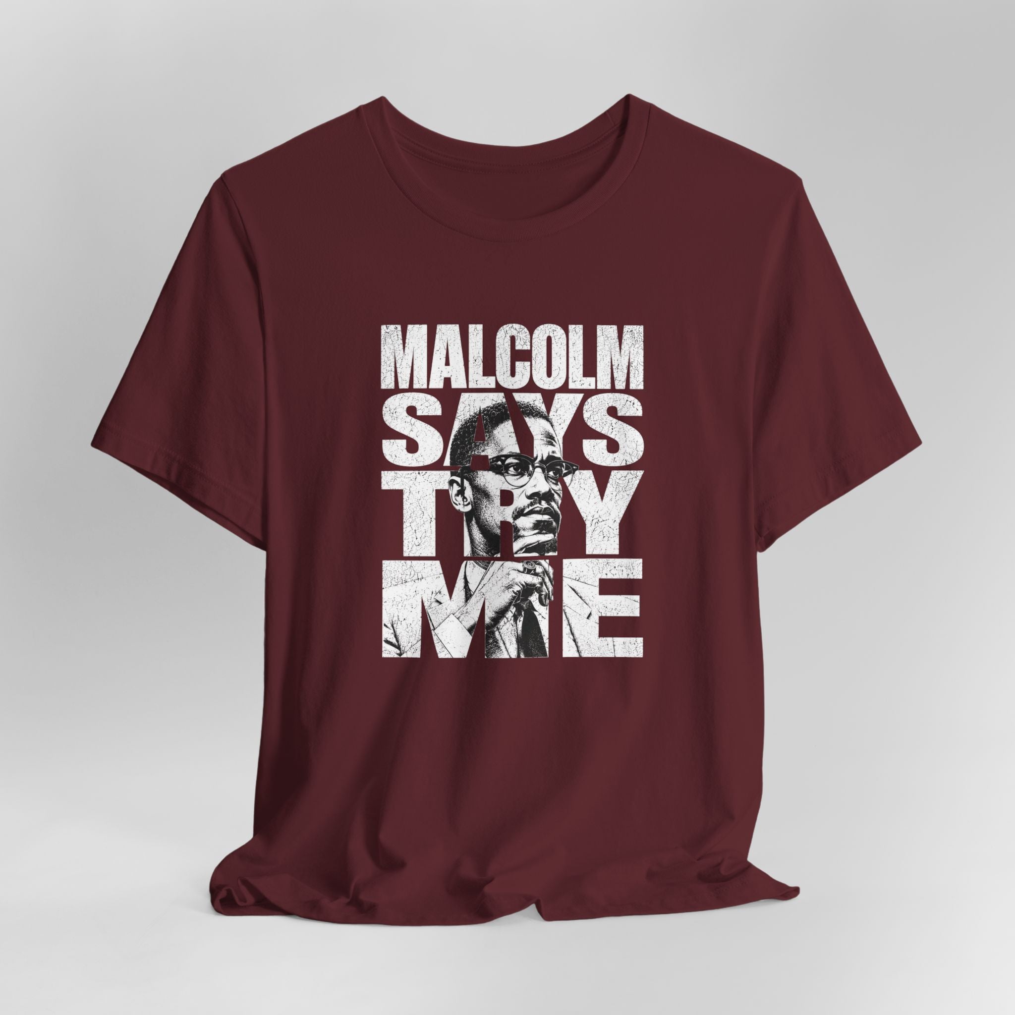 Maroon t-shirt with graphic design featuring a face and text on a gray background