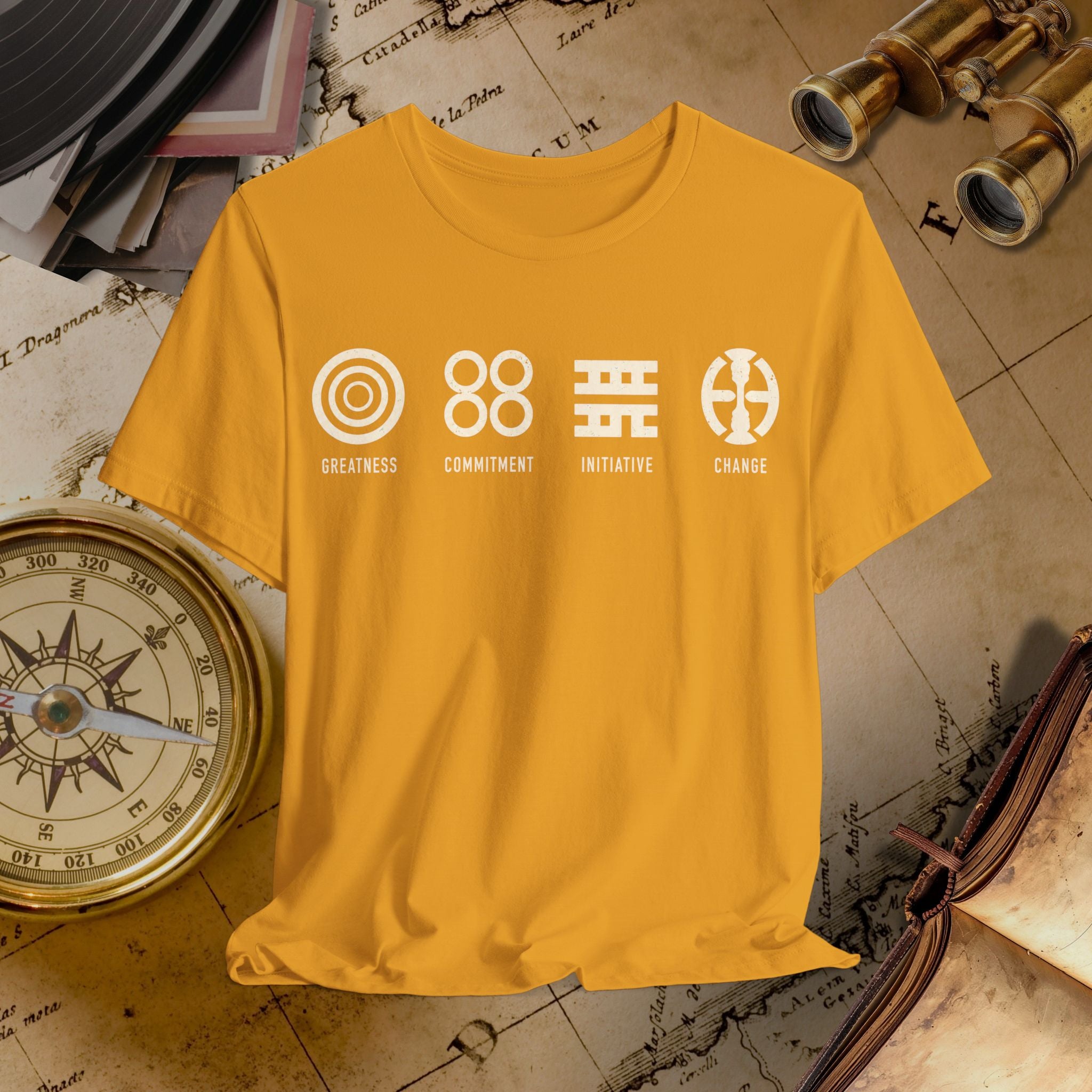 Mustard t-shirt with white graphics and text on a vintage map background