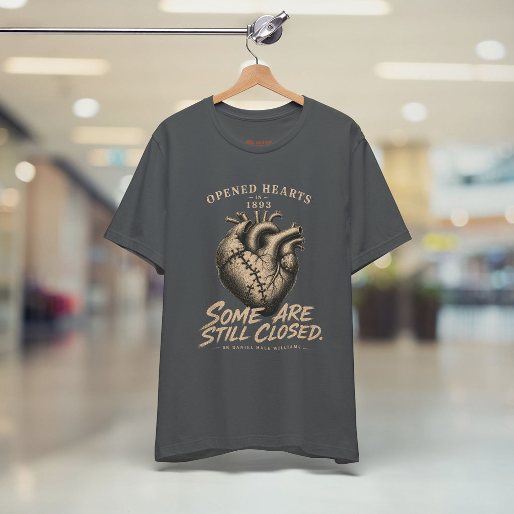 Gray t-shirt with a graphic design on a hanger in a store setting