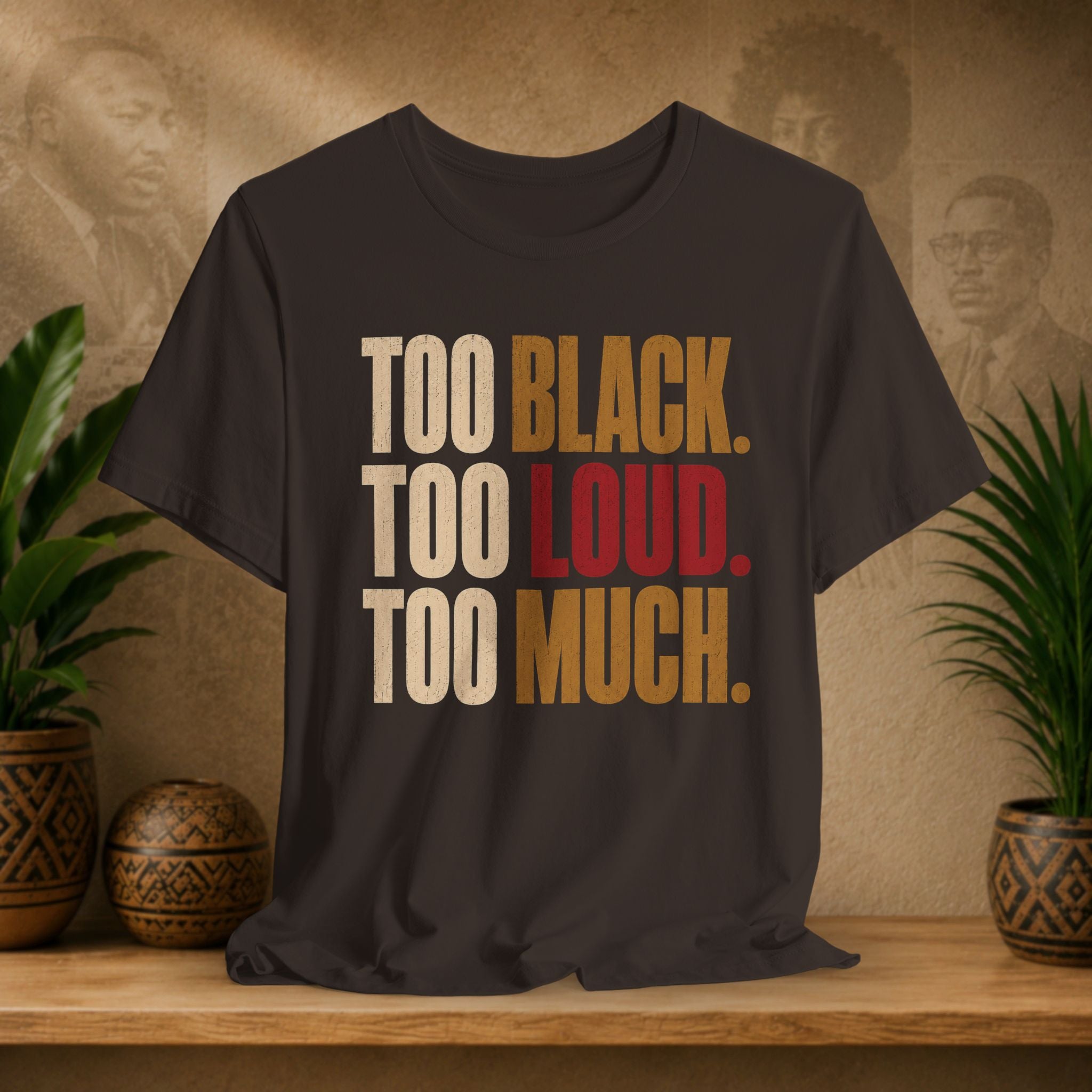 A brown t-shirt with a distressed typographic print reading 'TOO BLACK. TOO LOUD.