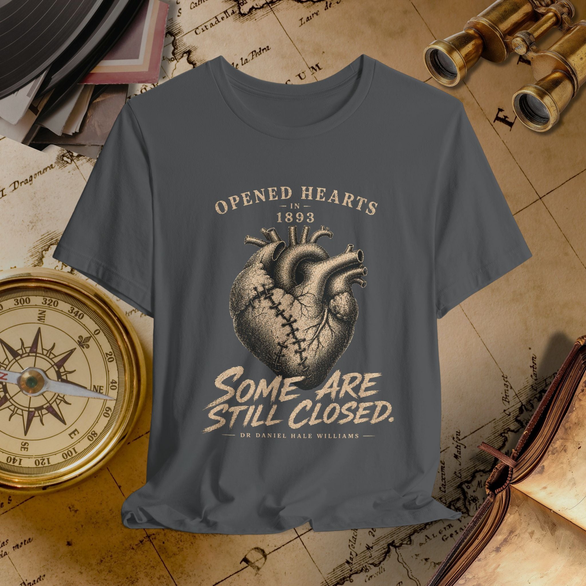 Gray t-shirt with heart design and text on a vintage map background